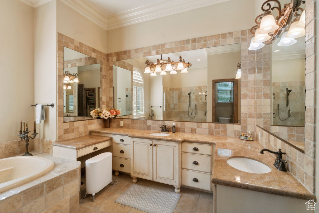 Full bathroom featuring a chandelier, crown molding, a bath, vanity, and tiled shower