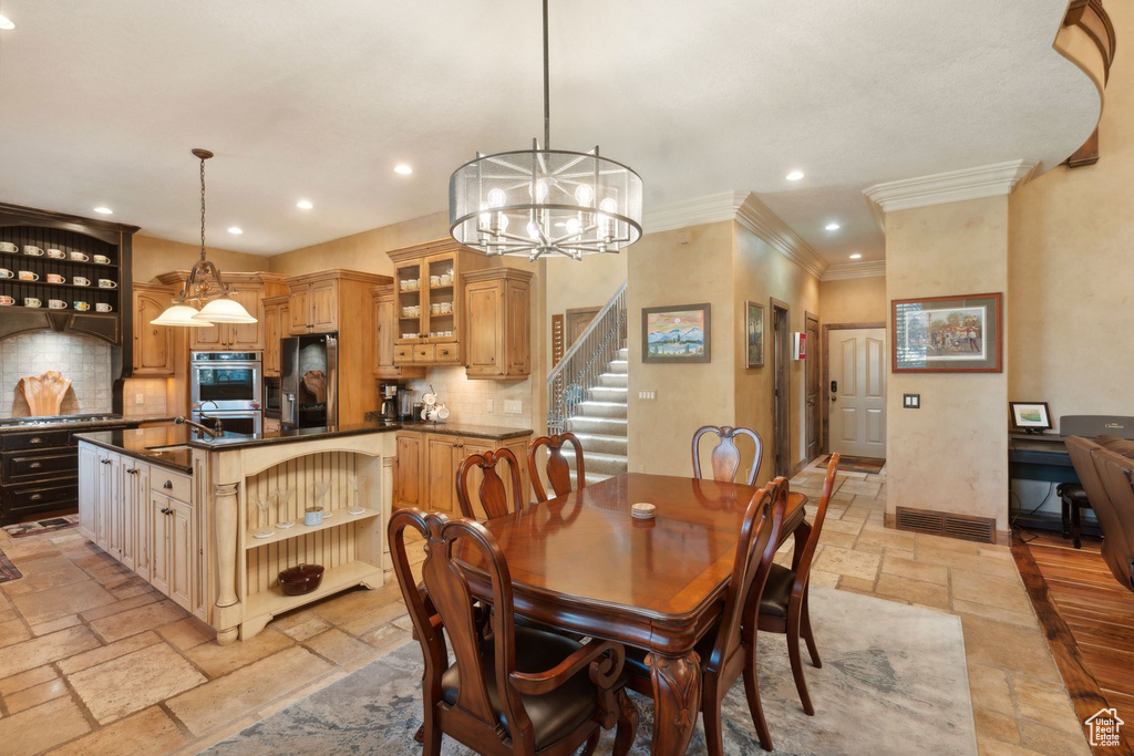 Dining room featuring stone tile floors, recessed lighting, ornamental molding, a chandelier, and stairs