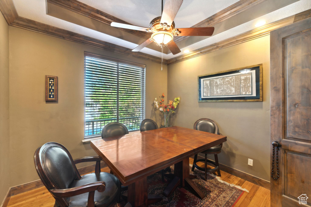 Dining room featuring baseboards, a ceiling fan, wood finished floors, crown molding, and a desk