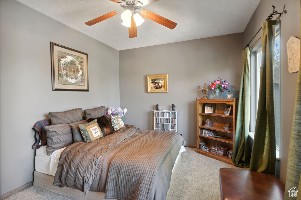Bedroom with carpet, baseboards, and a ceiling fan