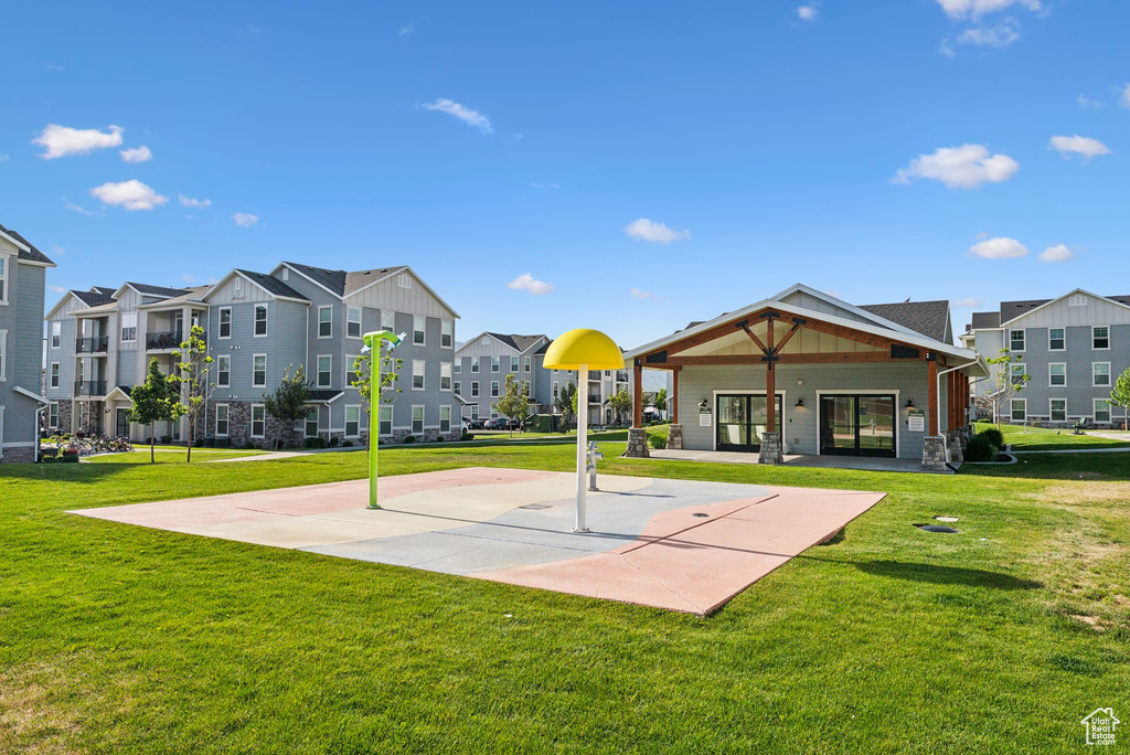 View of basketball court featuring a yard, a residential view, and community basketball court