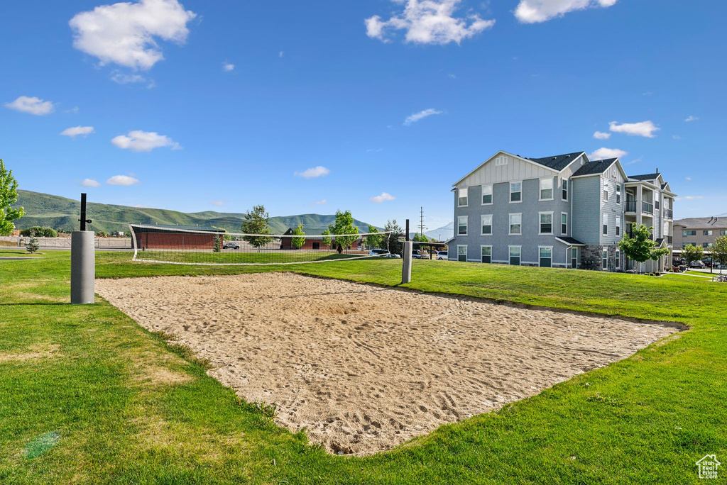 View of community with volleyball court, a mountain view, and a yard