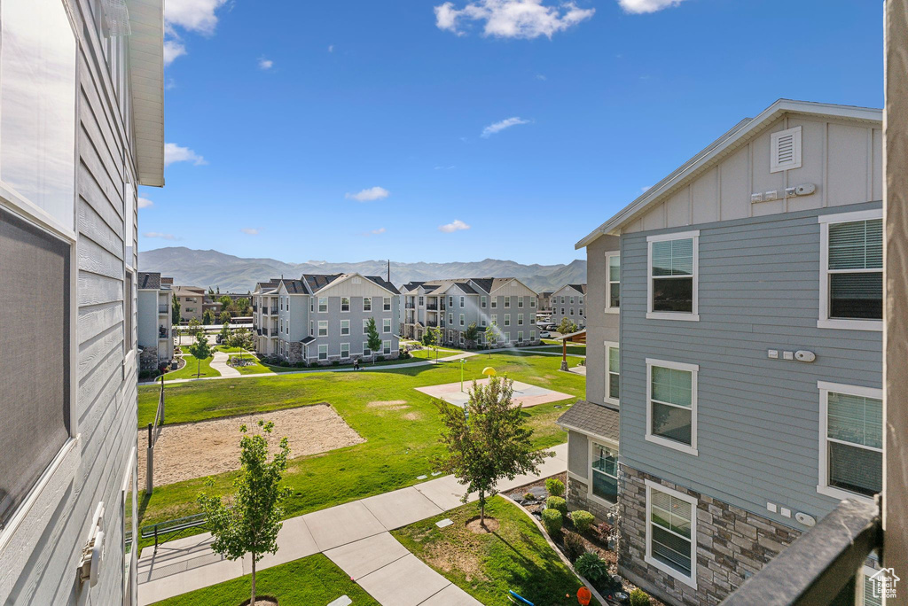 View of green lawn featuring a residential view and a mountain view