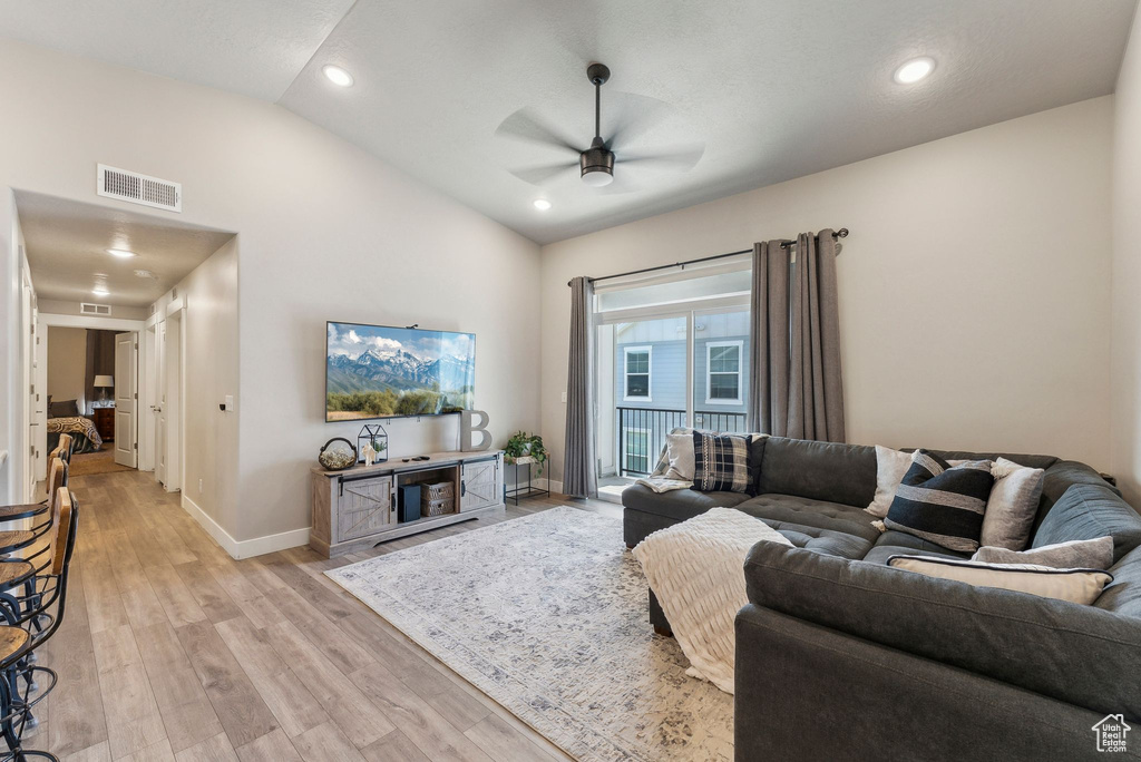 Living room with ceiling fan, vaulted ceiling, baseboards, light wood-type flooring, and recessed lighting