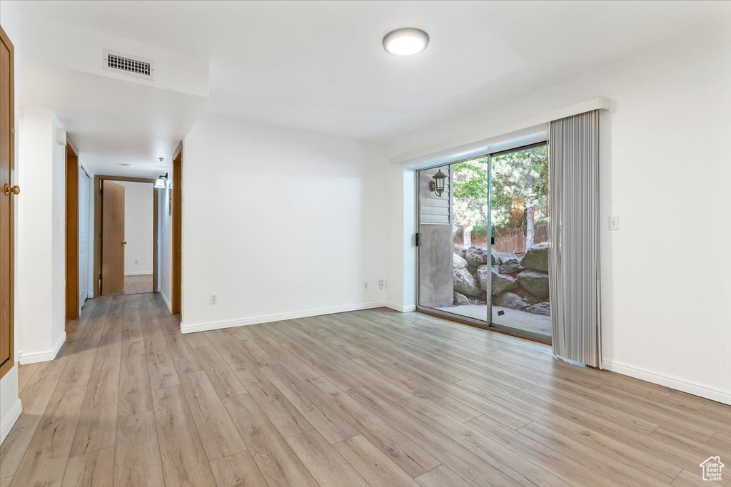 Unfurnished room with light wood-style flooring and baseboards