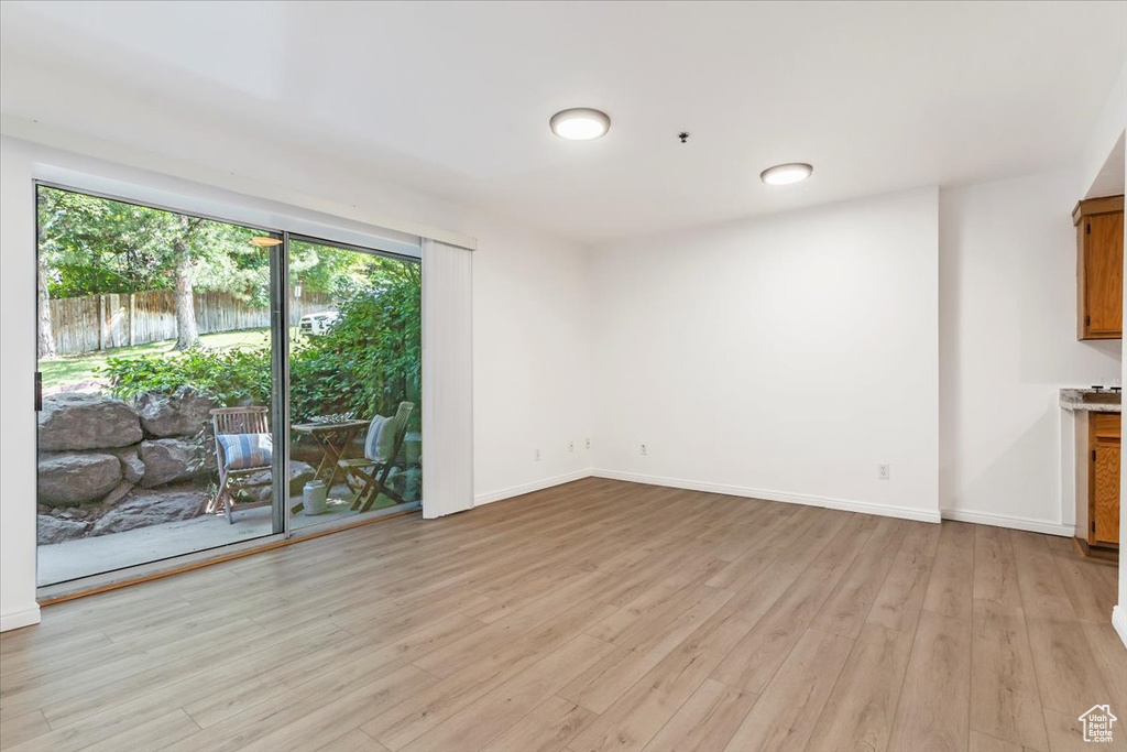 Unfurnished living room with light wood-style flooring and baseboards