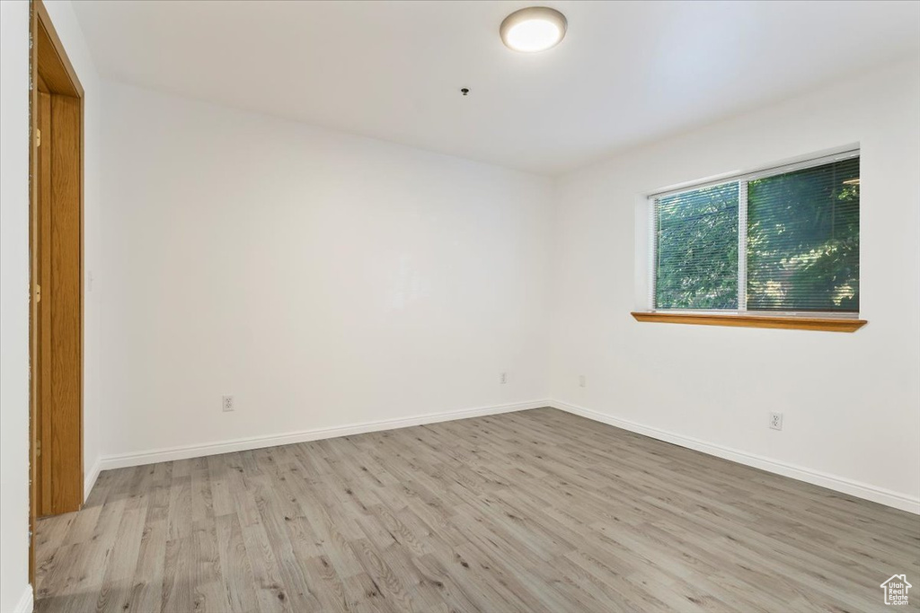 Unfurnished room with wood finished floors and baseboards