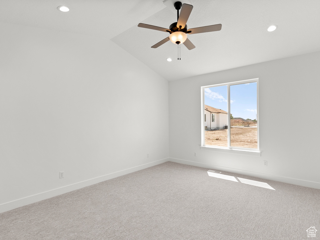 Empty room with vaulted ceiling, recessed lighting, light colored carpet, and a ceiling fan