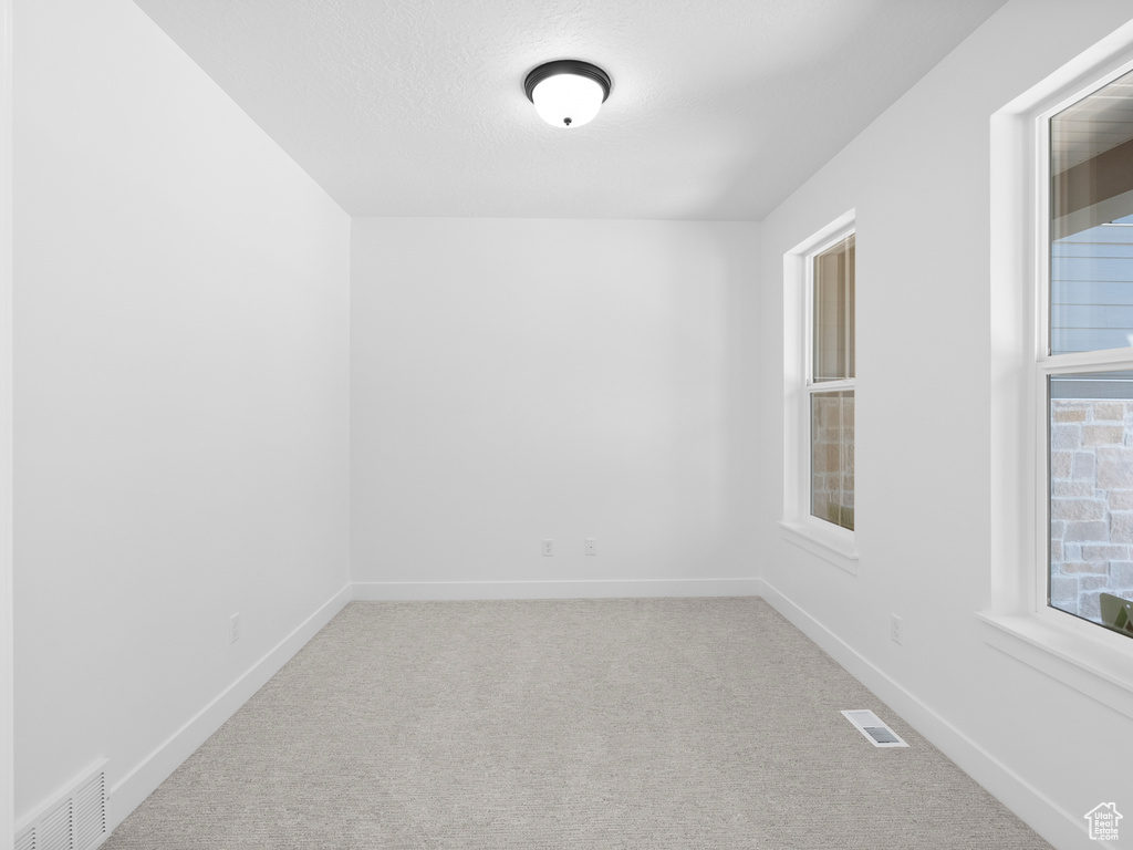 Carpeted empty room featuring baseboards