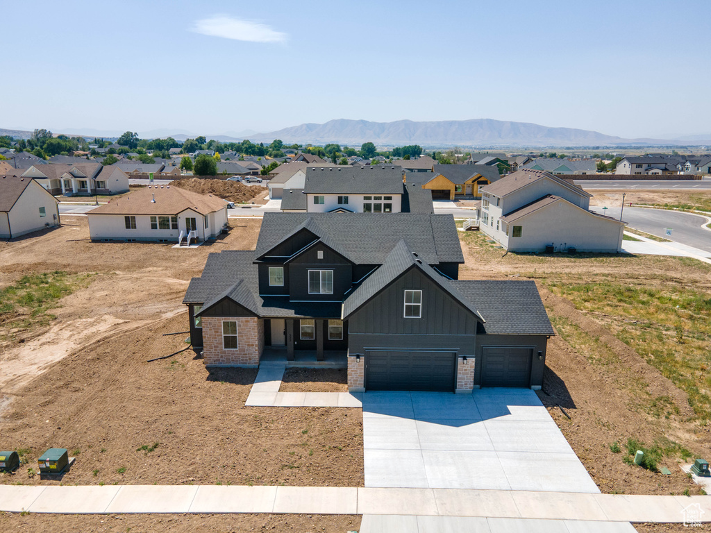 View of front of home featuring board and batten siding, driveway, a residential view, and brick siding