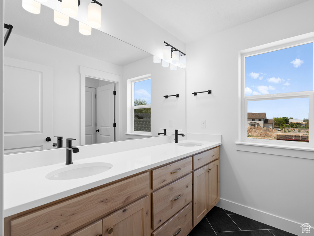 Bathroom with double vanity and tile patterned flooring
