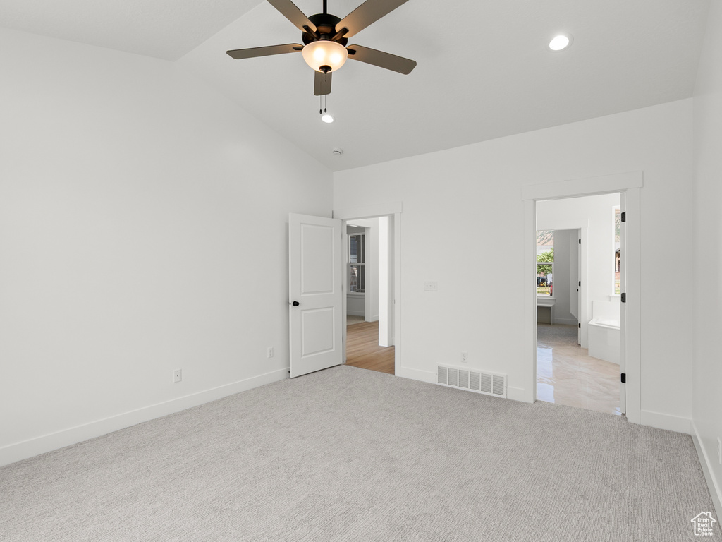 Unfurnished bedroom with light colored carpet, recessed lighting, ceiling fan, and high vaulted ceiling