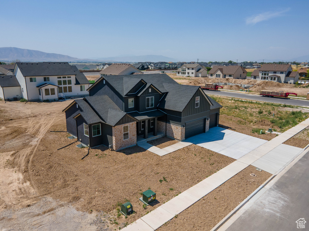 View of front of home featuring a residential view, board and batten siding, concrete driveway, and a shingled roof