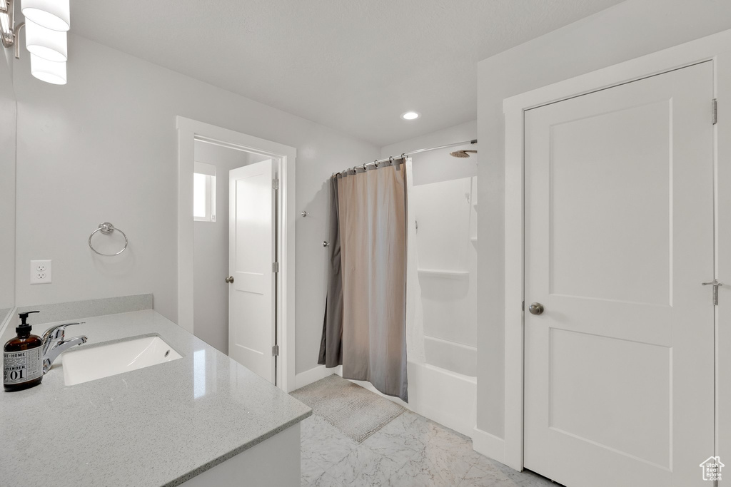 Bathroom featuring vanity, shower / bathtub combination with curtain, recessed lighting, and marble finish floors