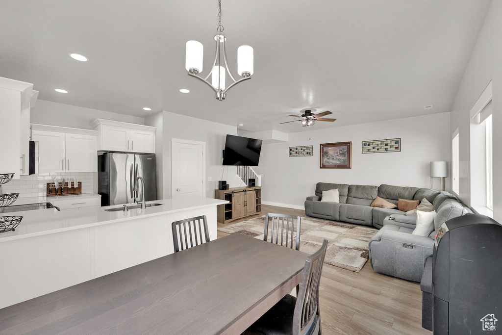Dining room featuring ceiling fan, light wood finished floors, a chandelier, recessed lighting, and baseboards