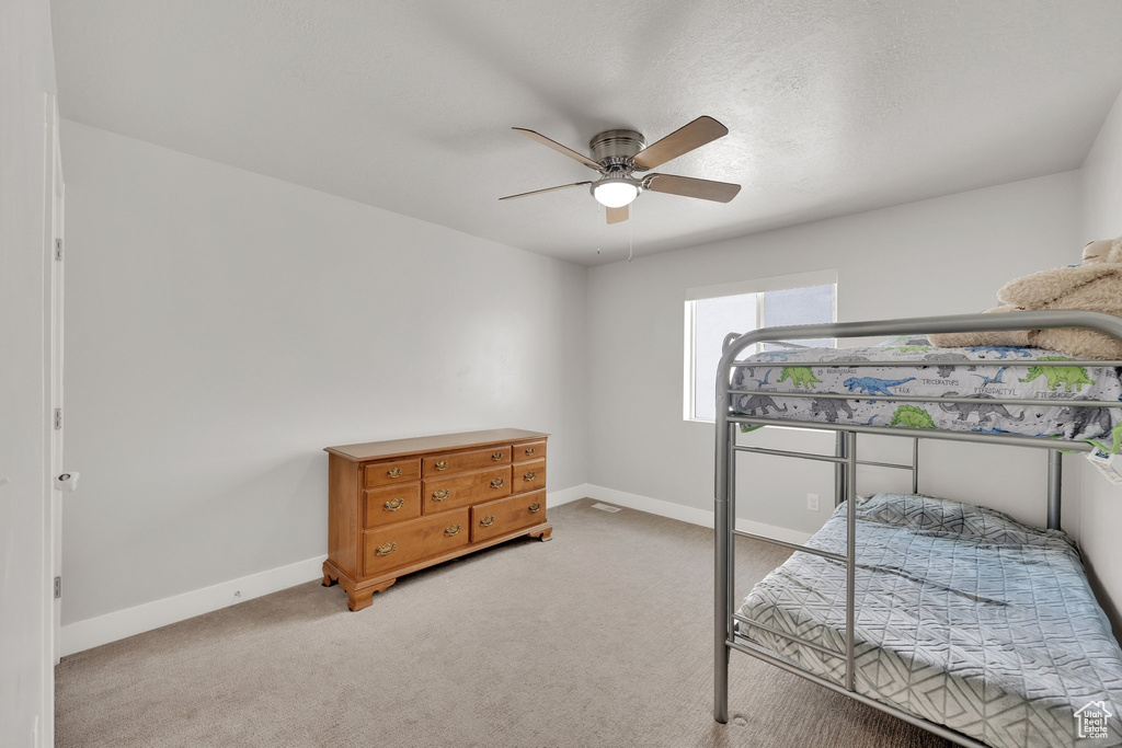 Bedroom with baseboards, light carpet, and ceiling fan