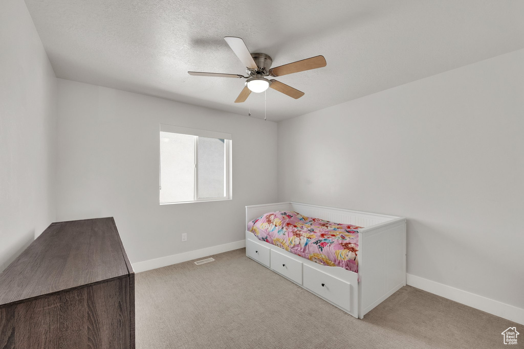 Carpeted bedroom featuring baseboards and a ceiling fan