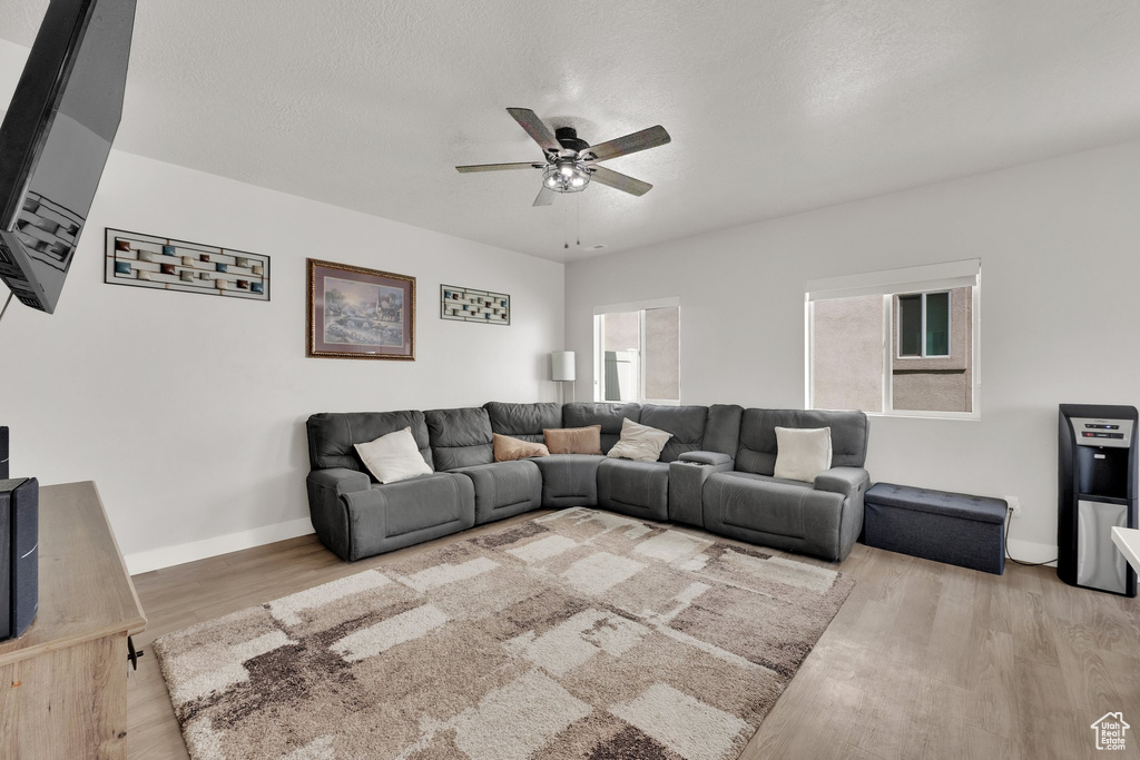 Living room featuring ceiling fan, wood finished floors, and baseboards