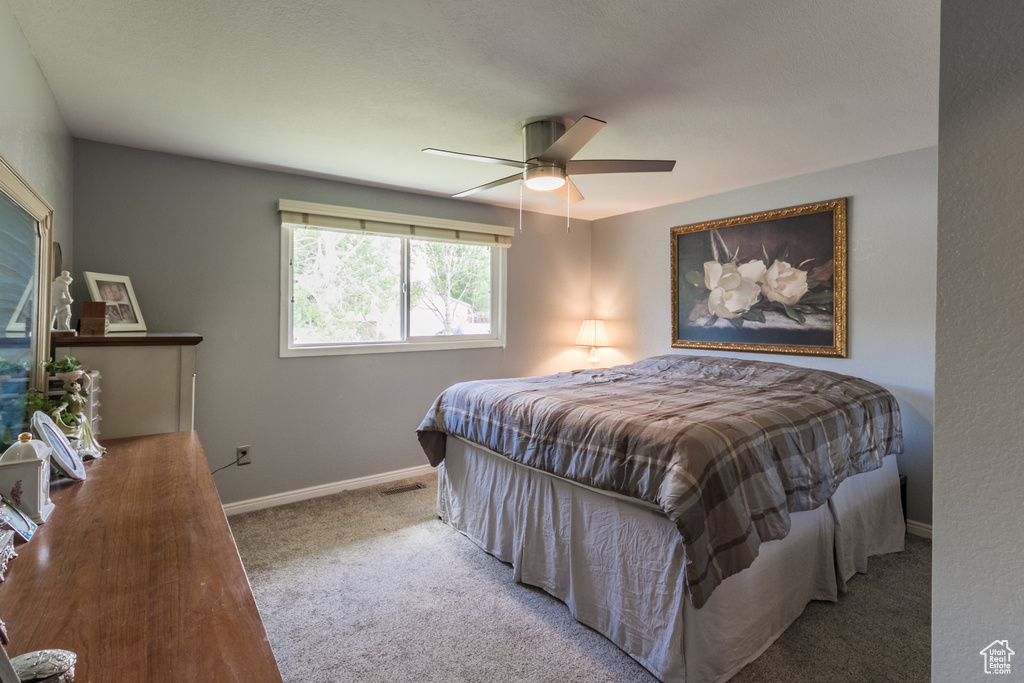 Carpeted bedroom with baseboards and a ceiling fan