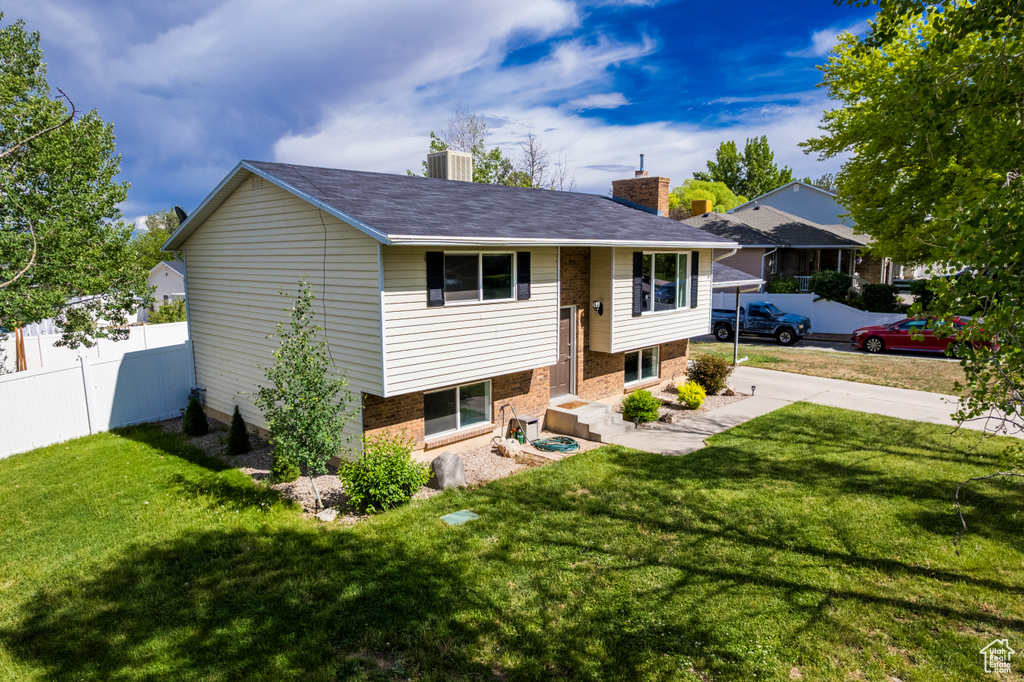 Split foyer home featuring a chimney and brick siding