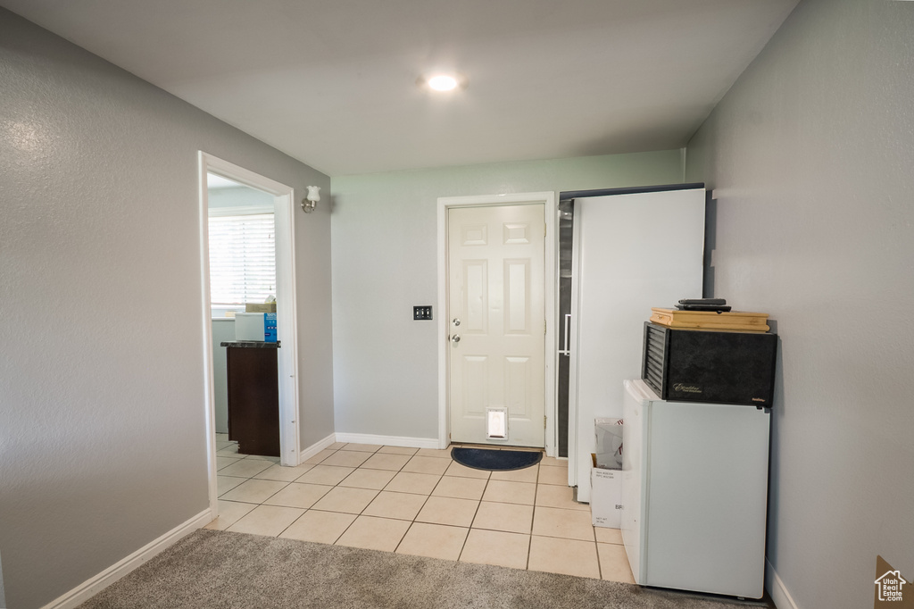 Entryway with light tile patterned flooring and baseboards