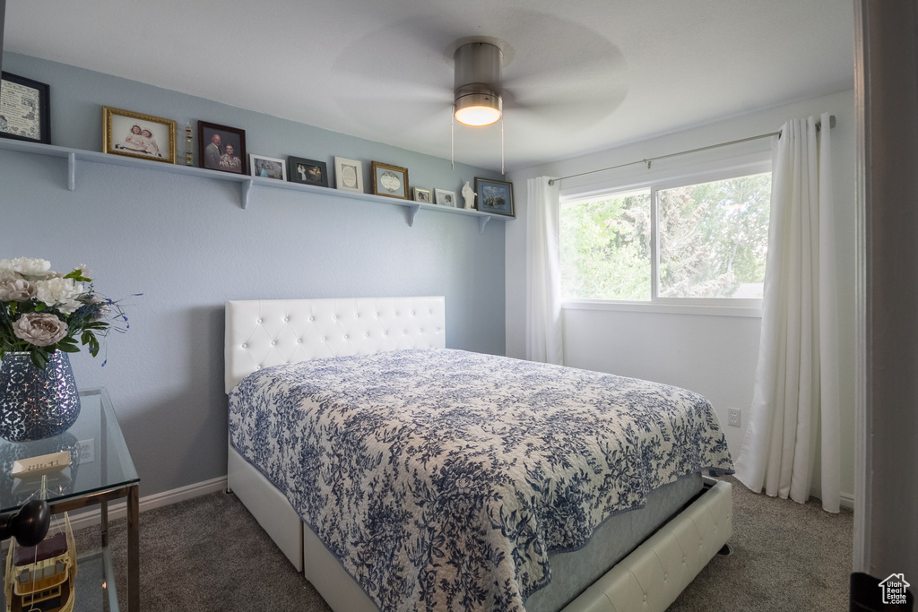 Carpeted bedroom with a ceiling fan