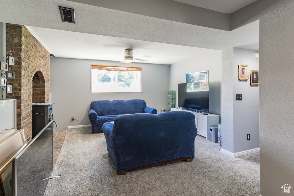 Living room featuring carpet floors, baseboards, and a fireplace