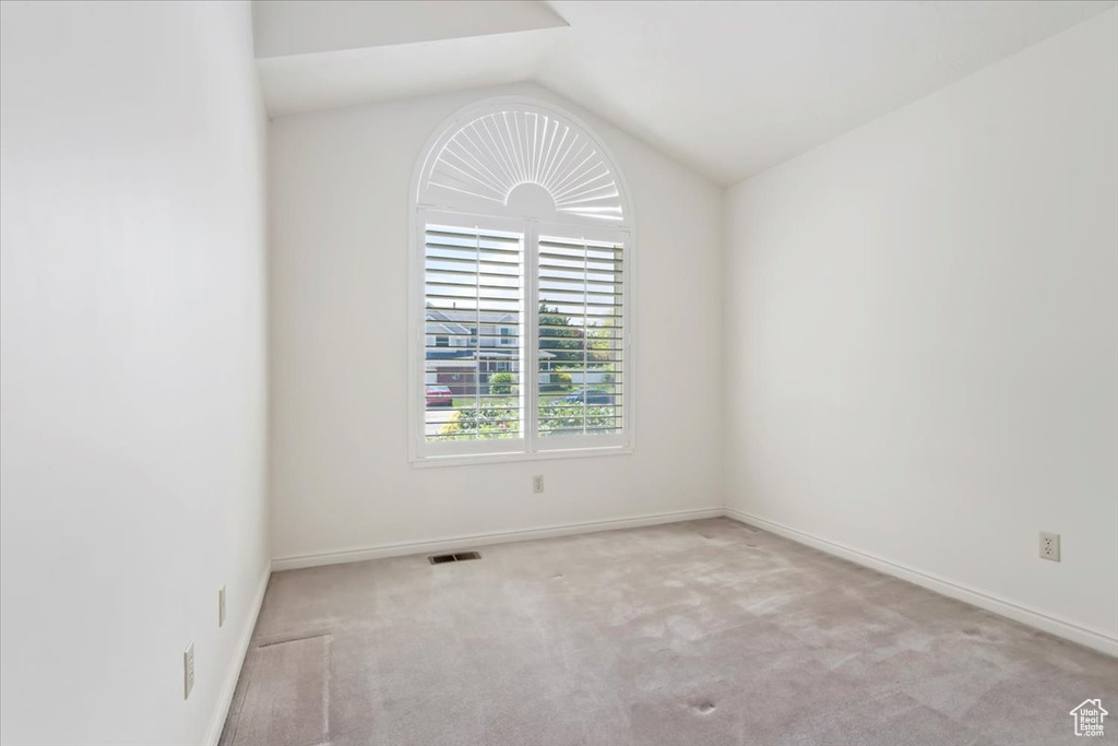 Unfurnished room with lofted ceiling, carpet floors, and baseboards