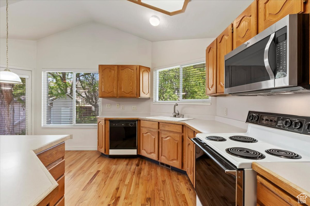 Kitchen featuring electric range oven, dishwasher, stainless steel microwave, a sink, and vaulted ceiling