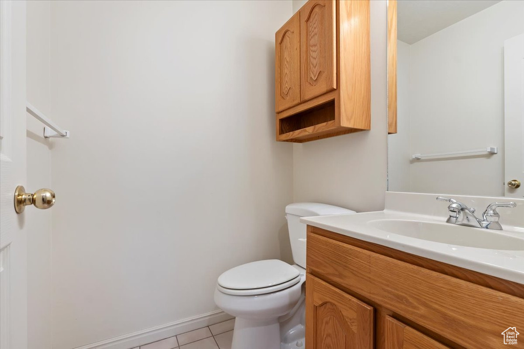 Bathroom with toilet, tile patterned flooring, and vanity