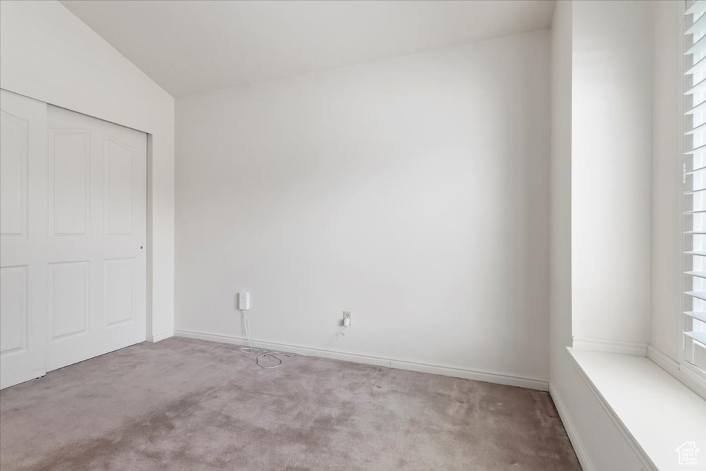 Unfurnished bedroom featuring carpet, a closet, and baseboards