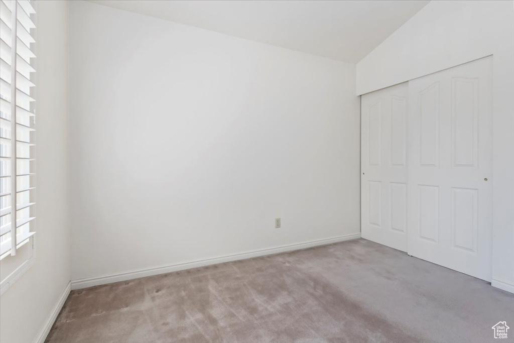 Unfurnished bedroom with carpet flooring, a closet, and baseboards