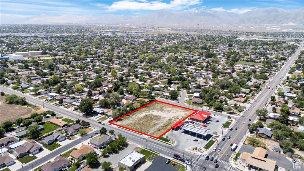 Aerial view of property and surrounding area with property boundaries highlighted and a mountainous background