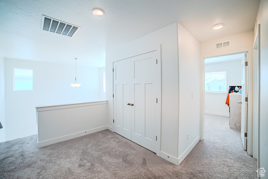 Corridor featuring carpet flooring and baseboards