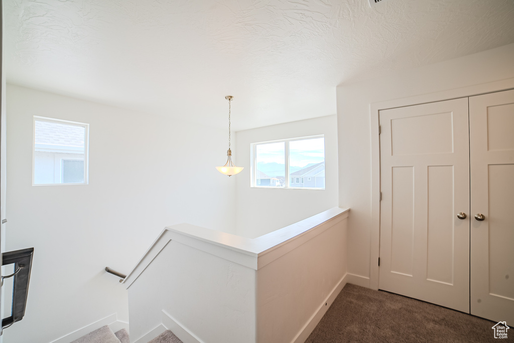 Corridor featuring carpet and baseboards