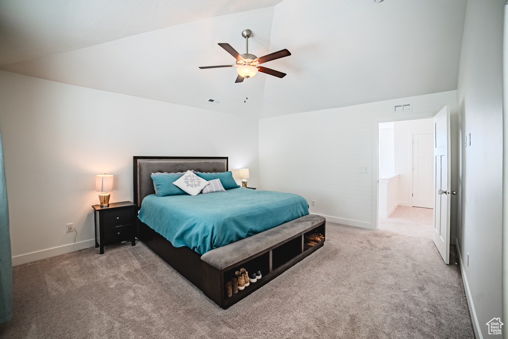 Carpeted bedroom featuring vaulted ceiling, baseboards, and ceiling fan