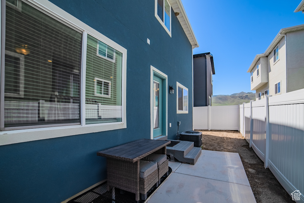 Fenced backyard featuring a patio, central AC, and a mountain view