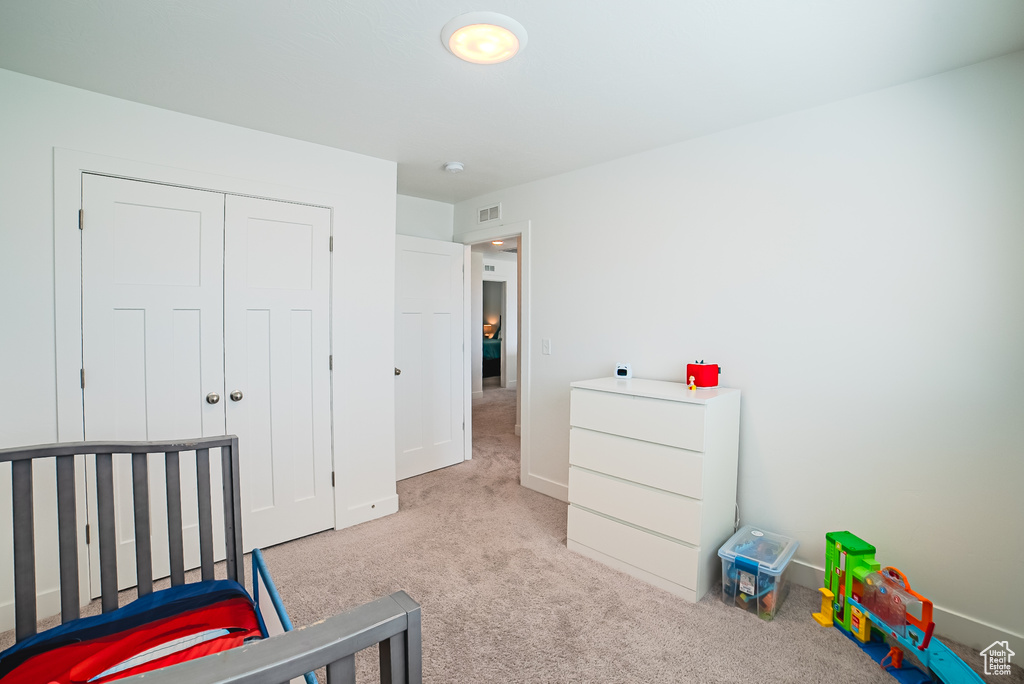 Carpeted bedroom with baseboards and a closet