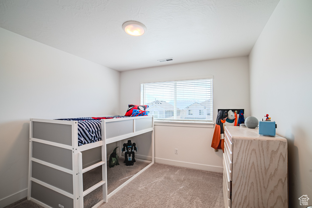 Bedroom featuring light carpet and baseboards