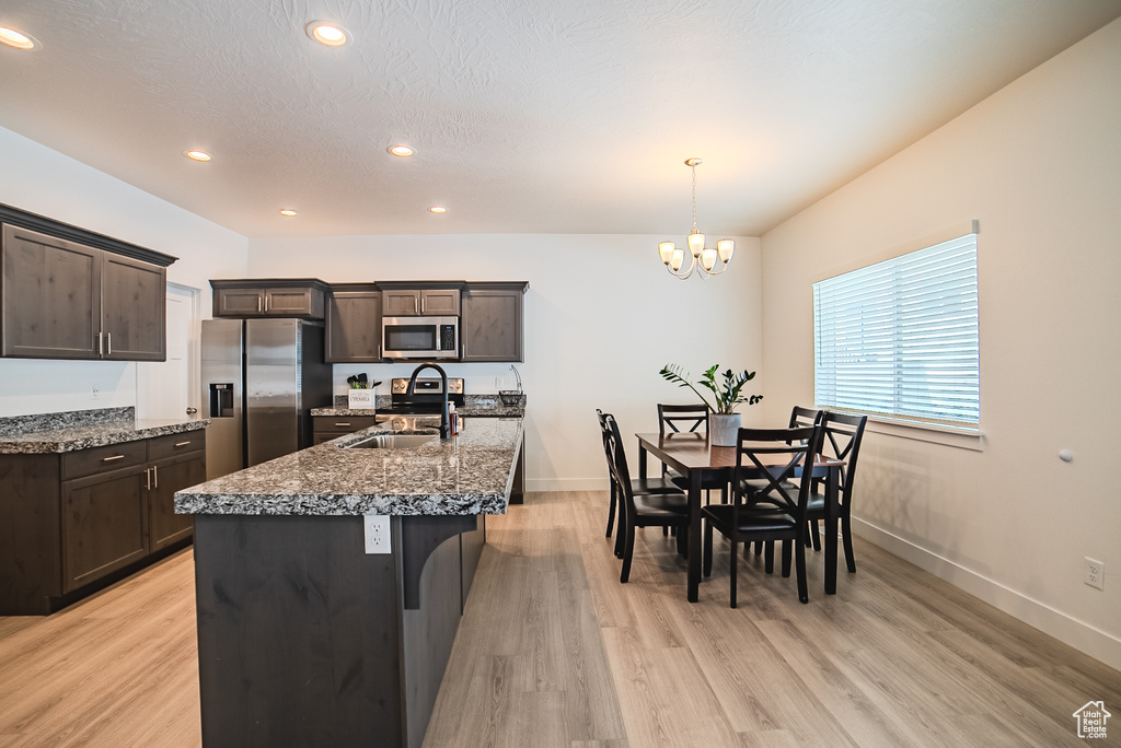 Kitchen featuring a sink, appliances with stainless steel finishes, dark brown cabinets, a chandelier, and recessed lighting