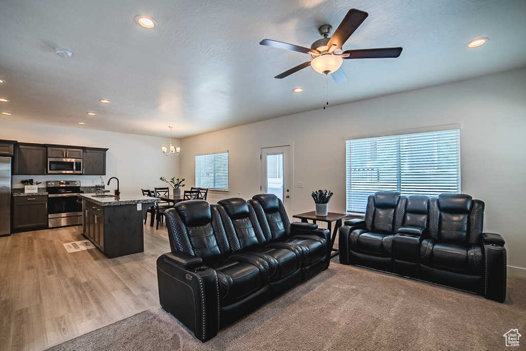 Living room featuring a chandelier, recessed lighting, ceiling fan, and light wood-type flooring