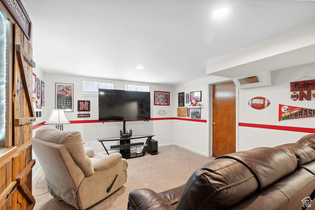 Carpeted living area with recessed lighting and baseboards
