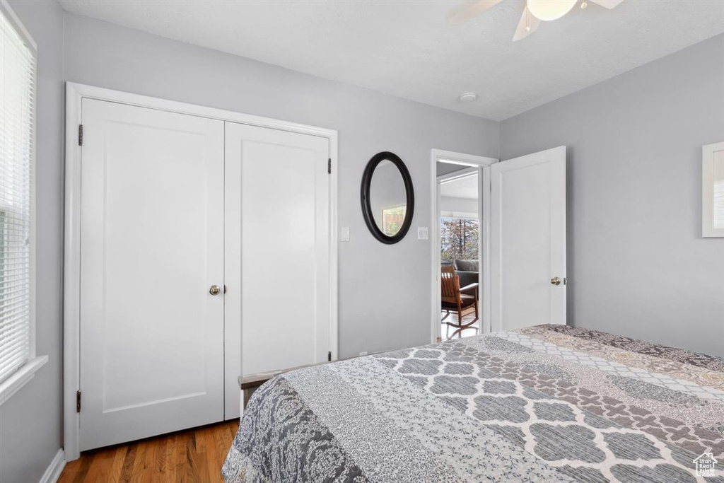 Bedroom with wood finished floors, a closet, and ceiling fan