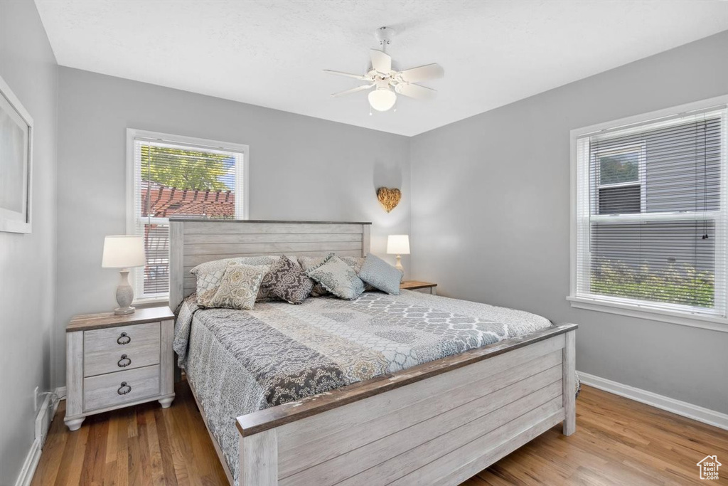 Bedroom featuring baseboards, wood finished floors, and ceiling fan
