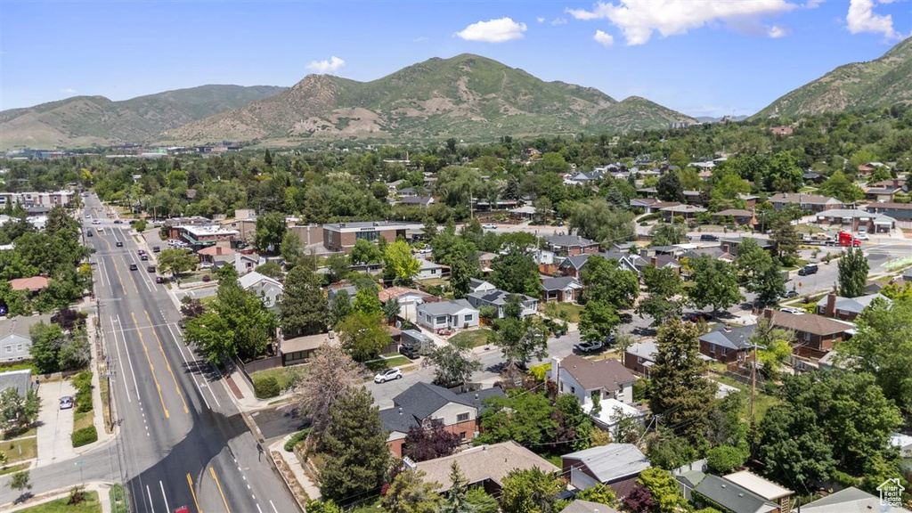 Aerial view of property and surrounding area with a mountainous background and nearby suburban area