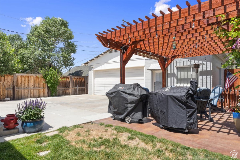 View of patio featuring a garage and a pergola