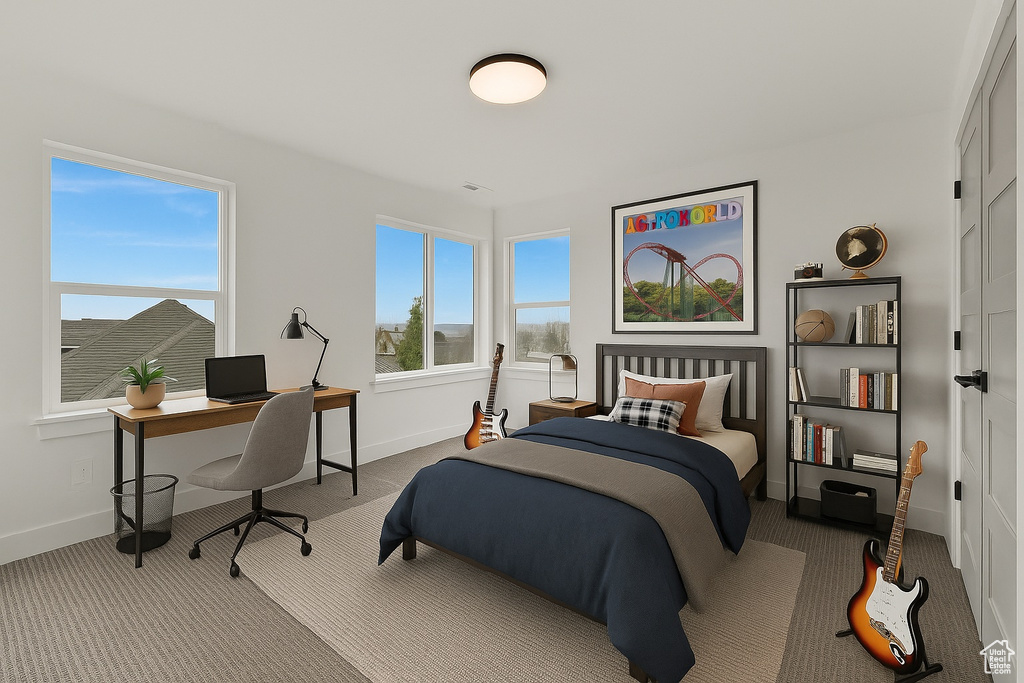 Carpeted bedroom with baseboards and an office area