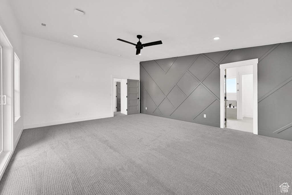 Unfurnished living room featuring ceiling fan, carpet flooring, recessed lighting, baseboards, and a decorative wall
