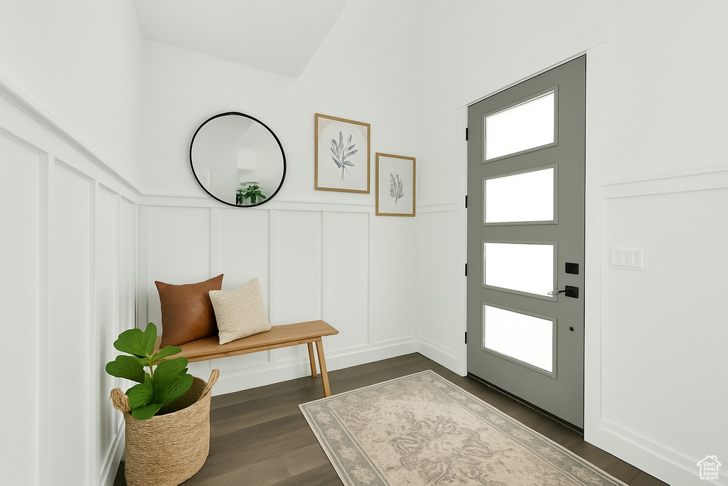 Foyer entrance featuring a decorative wall, dark wood finished floors, and a wainscoted wall