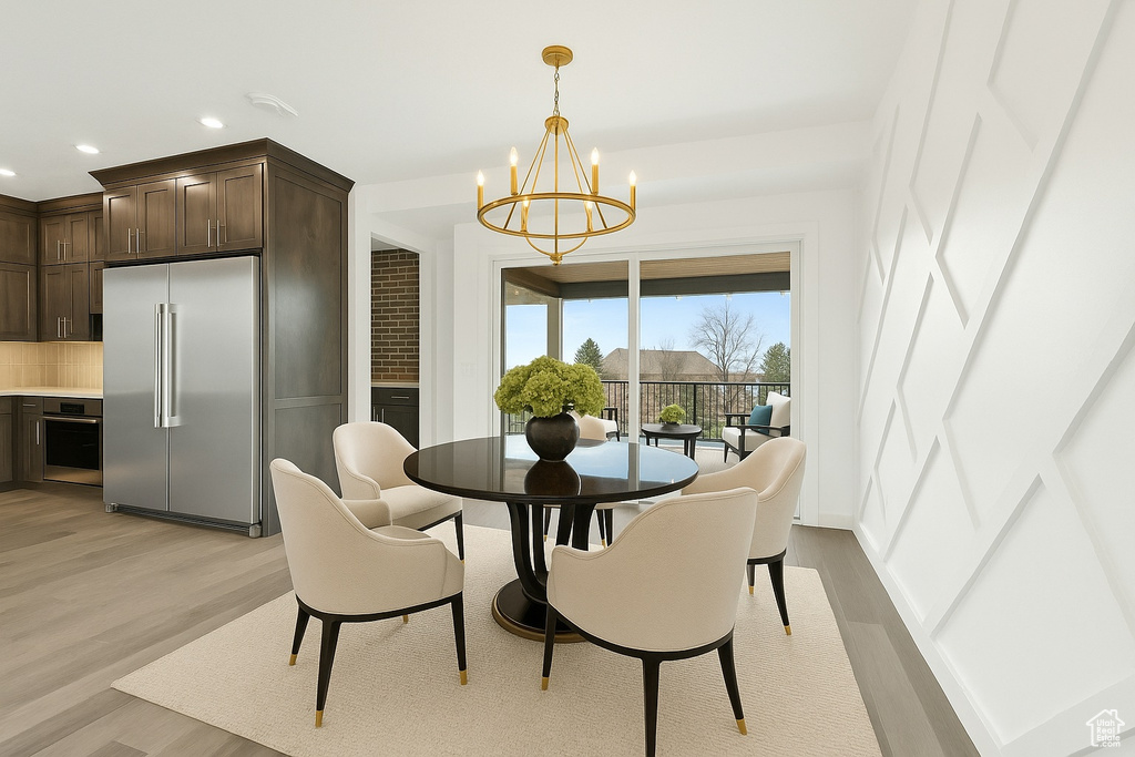 Dining space featuring light wood-style flooring, a chandelier, and recessed lighting